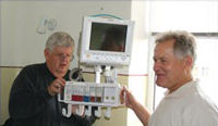 David Harrington and Sam Downing, set up a Philips bedside monitor in the emergency room.